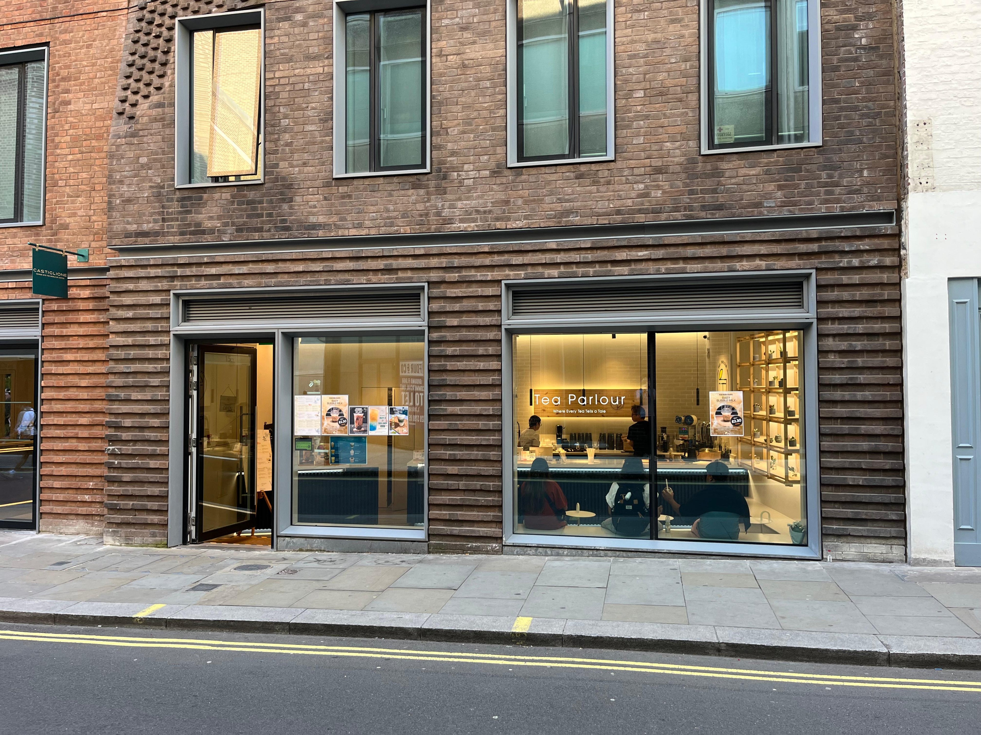 Tea Parlour’s storefront with large glass windows on a brick building, located near Trafalgar Square in Central London.
