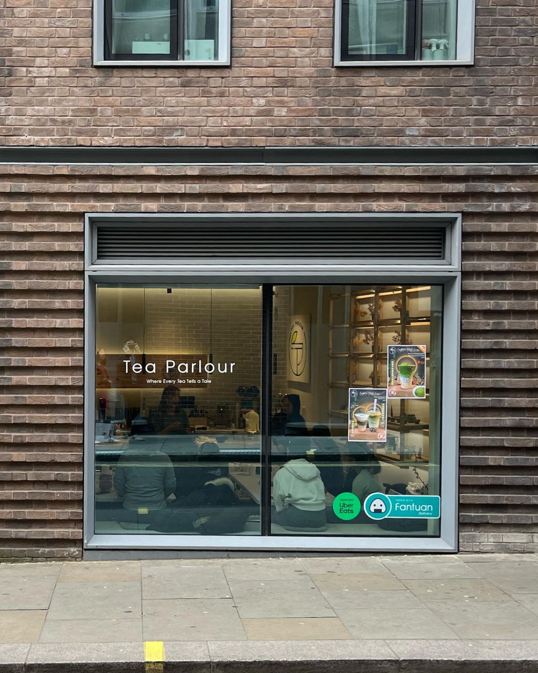 Tea Parlour storefront window view near the National Gallery in London, showing customers inside during a matcha event with posters and interior decor visible.